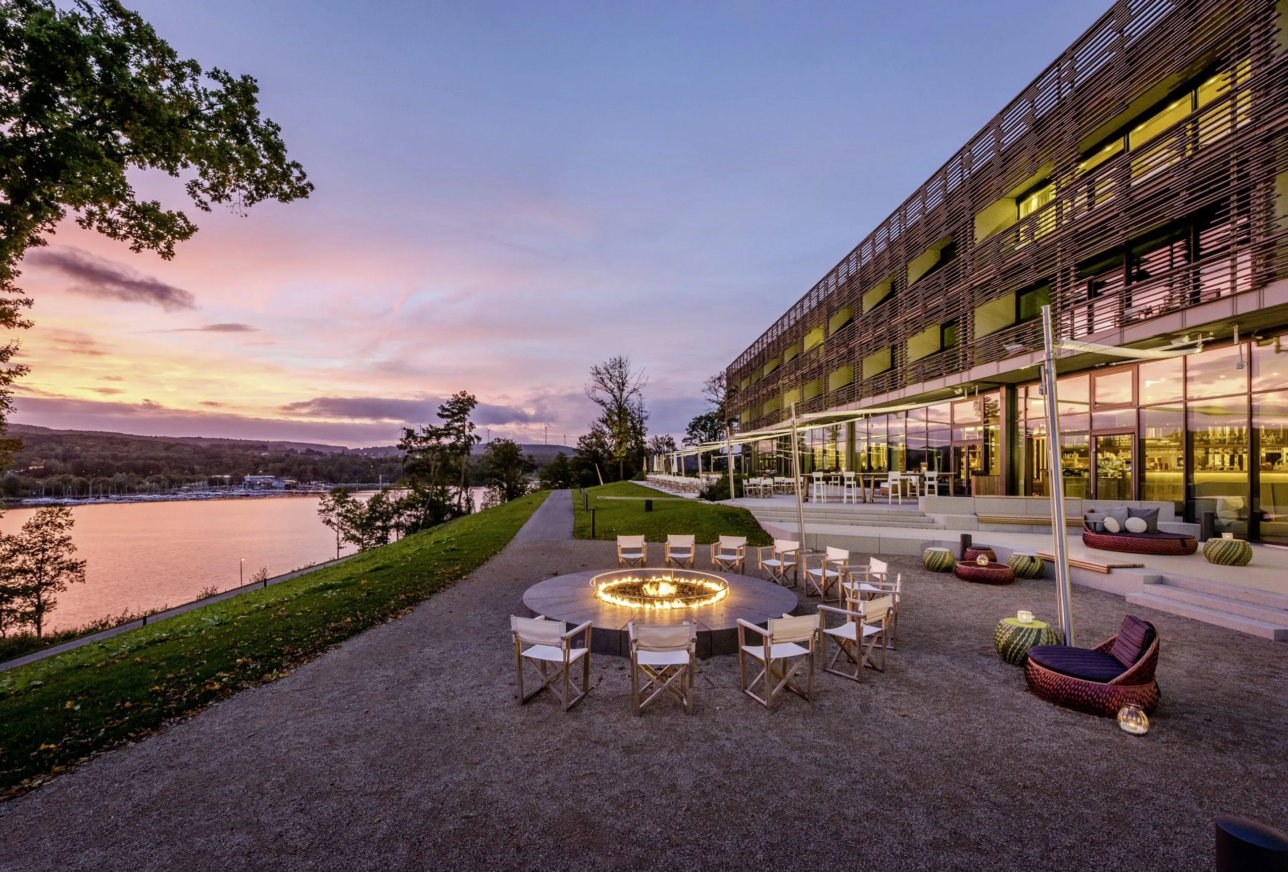 Fassade der Seezeitlodge im Abendrot mit Feuerstelle und Seeblick