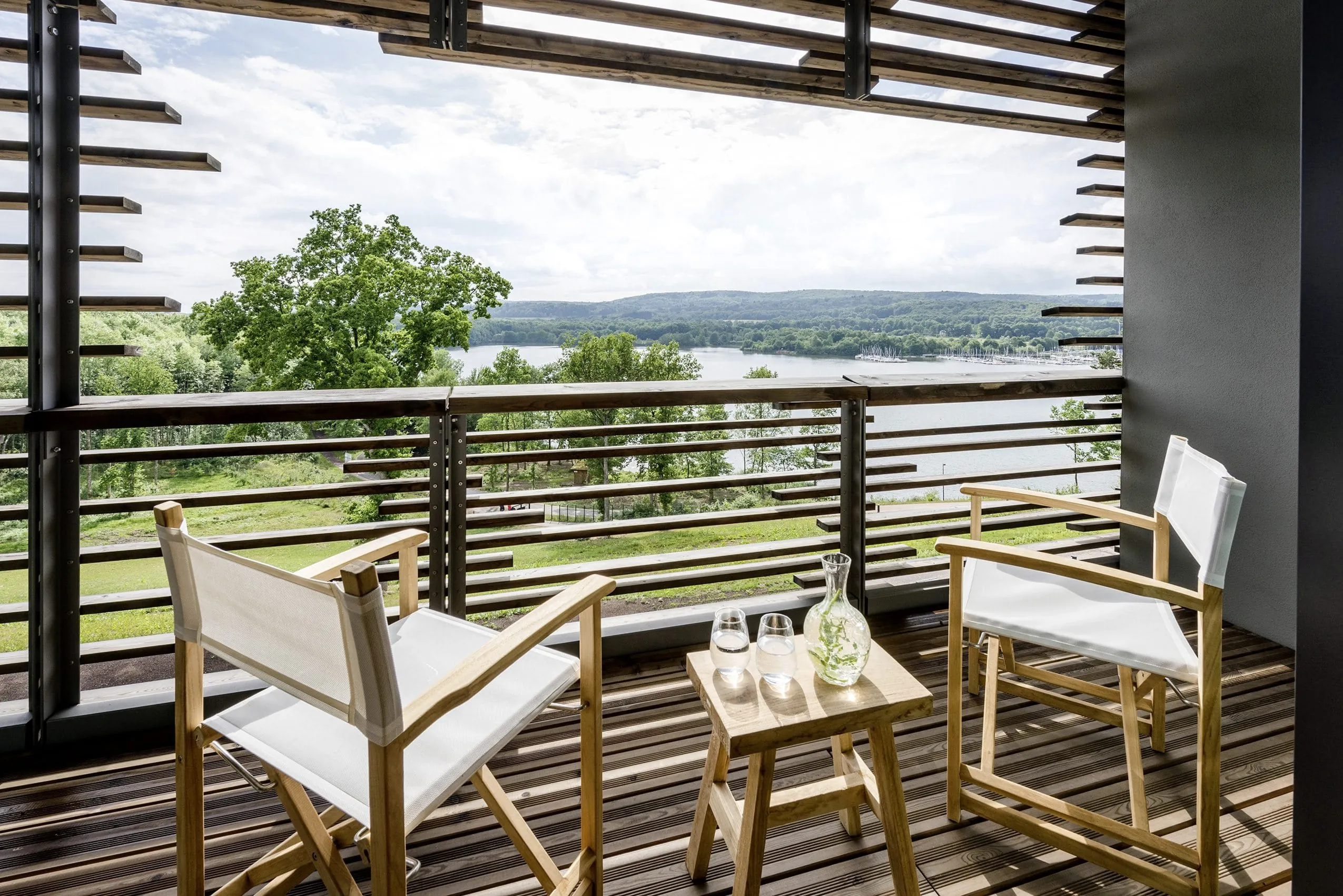 zwei Regiest&uuml;hle mit kleinem Tisch auf dem Balkon der Seezeitlodge mit Blick auf den See