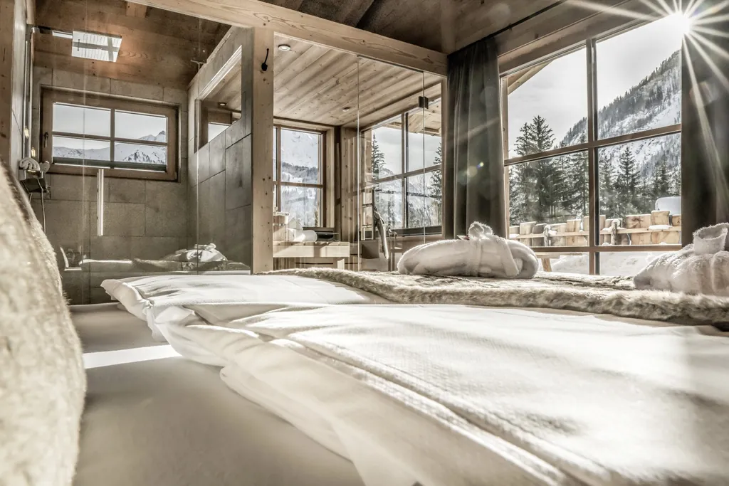 Blick aus dem Schlafzimmer im Chalet mit offener Dusche und privater Sauna im Winter