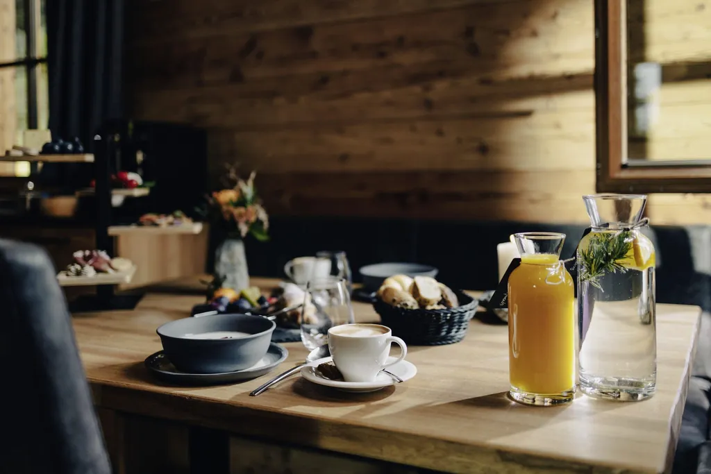 Gedeckter Frühstückstisch mit Etagere, Orangensaft und frischem Quellwasser
