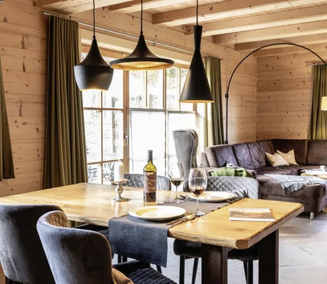 Modern eingerichtetes Wohnzimmer mit Esstisch und Polsterstühlen im Beim Waicher Chalets & Apartments