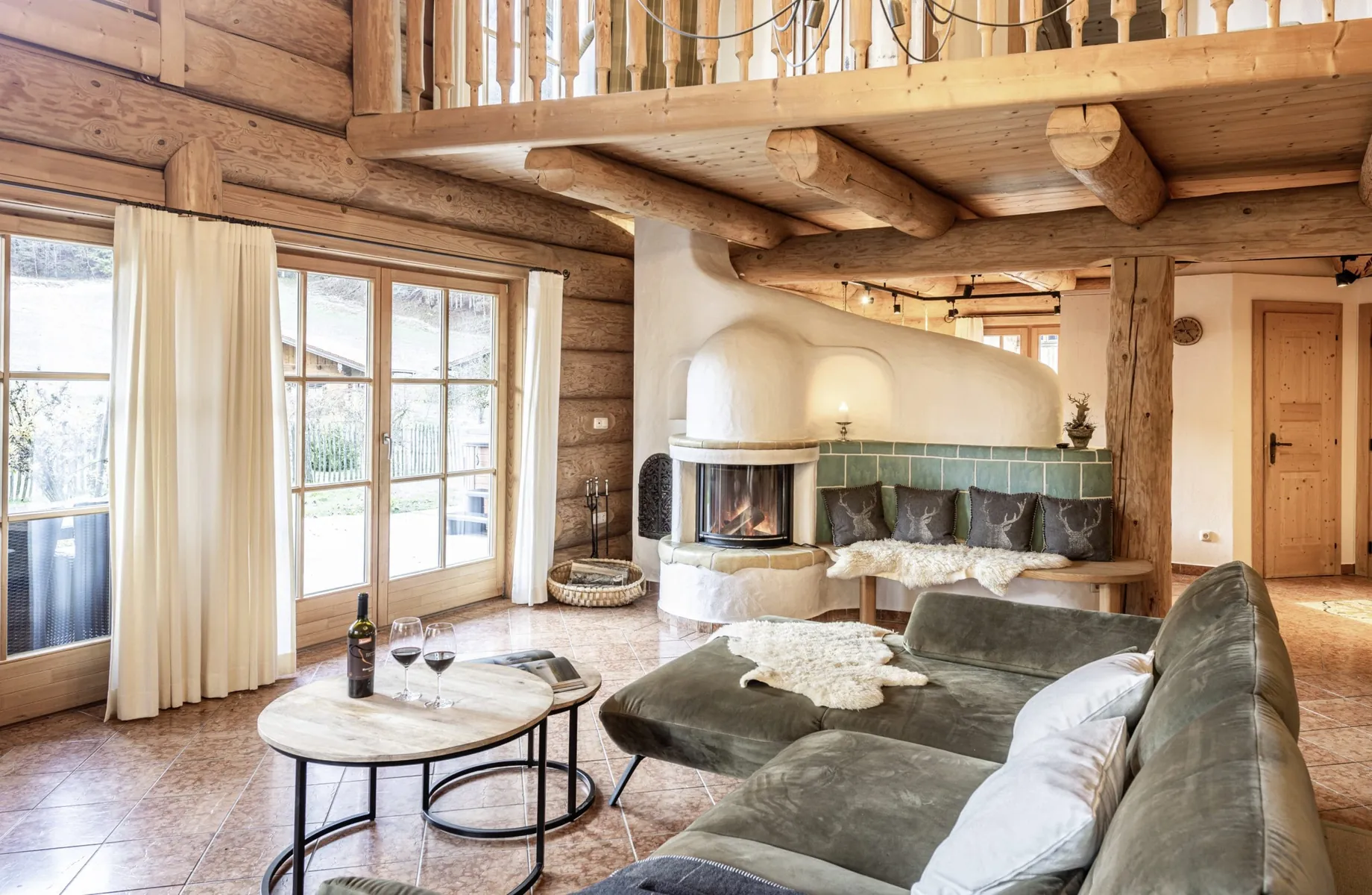 Wohnbereich im Naturstammhaus der Beim Waicher Chalets & Apartments mit Sofa und Kachelofen