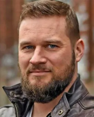 Autorenporträt Hannes Finkbeiner mit Vollbart und Lederjacke