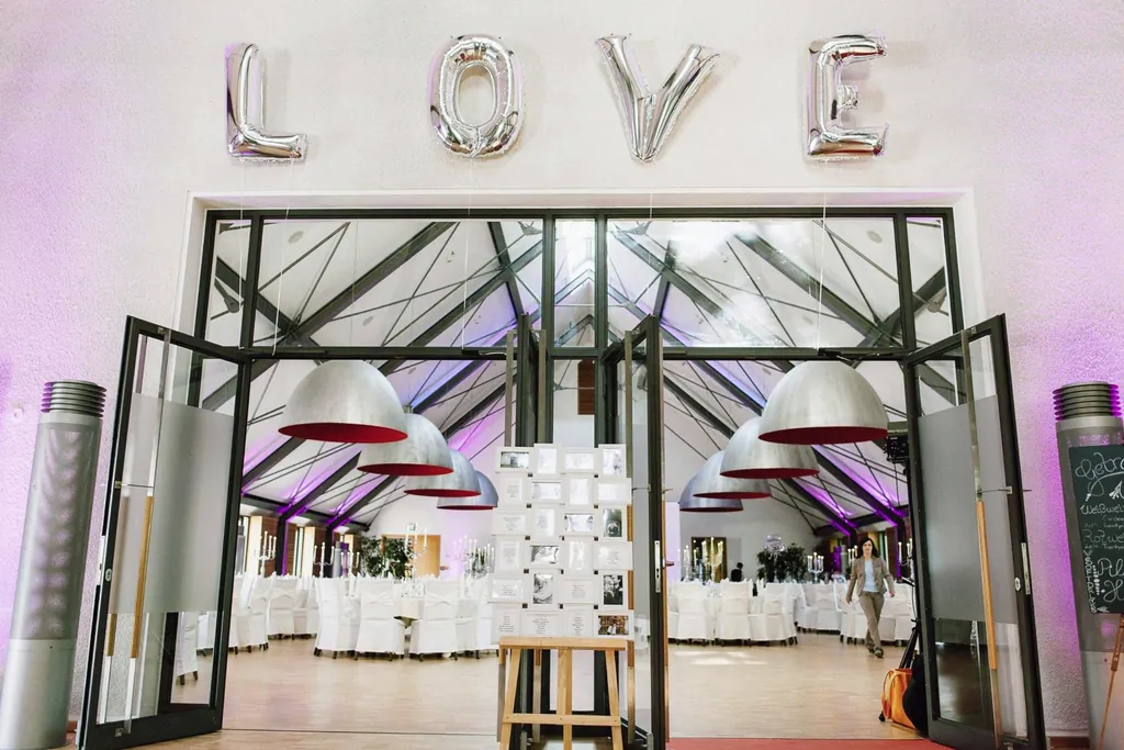 Festsaal mit großen Lampen und gedeckten Tischen im Schloss Hohenkammer.