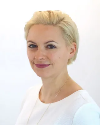 Autorenporträt Julia Breitkopf lächelnd mit weißem Oberteil im Freiviertelprofil