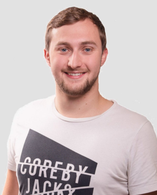 Autorenporträt Max Herrmannsdörfer lächelnd mit Bart und weißem T-Shirt mit schwarzem Aufdruck