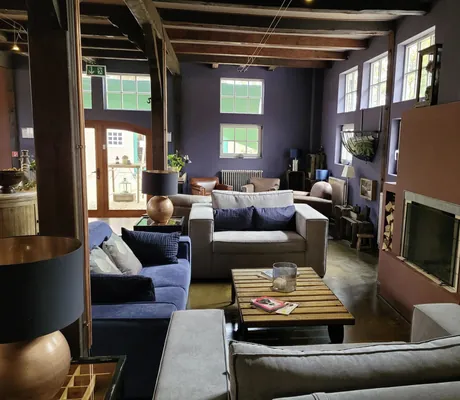 Loungemöbel vor dem offenen Kamin unter dem Dach in Gut Thansen