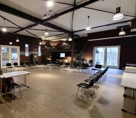 großer Tagungsraum unter dem Dach mit schwarzen Stühlen im Stuhlkreis im Gut Thansen