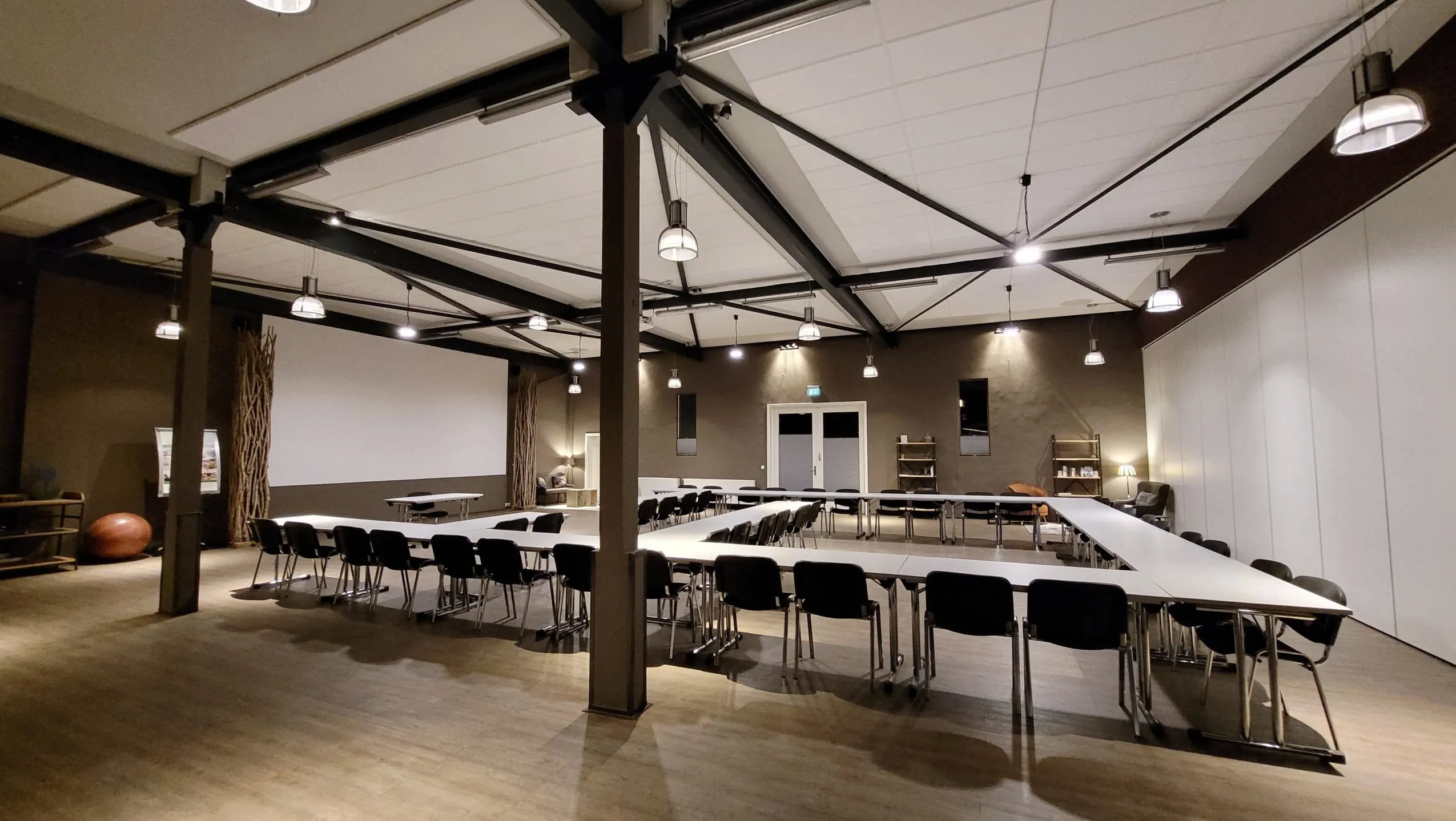 gro&szlig;er Tagungsraum mit S&auml;ulen, wei&szlig;en Konferenztischen und wei&szlig;en St&uuml;hlen im Gut Thansen