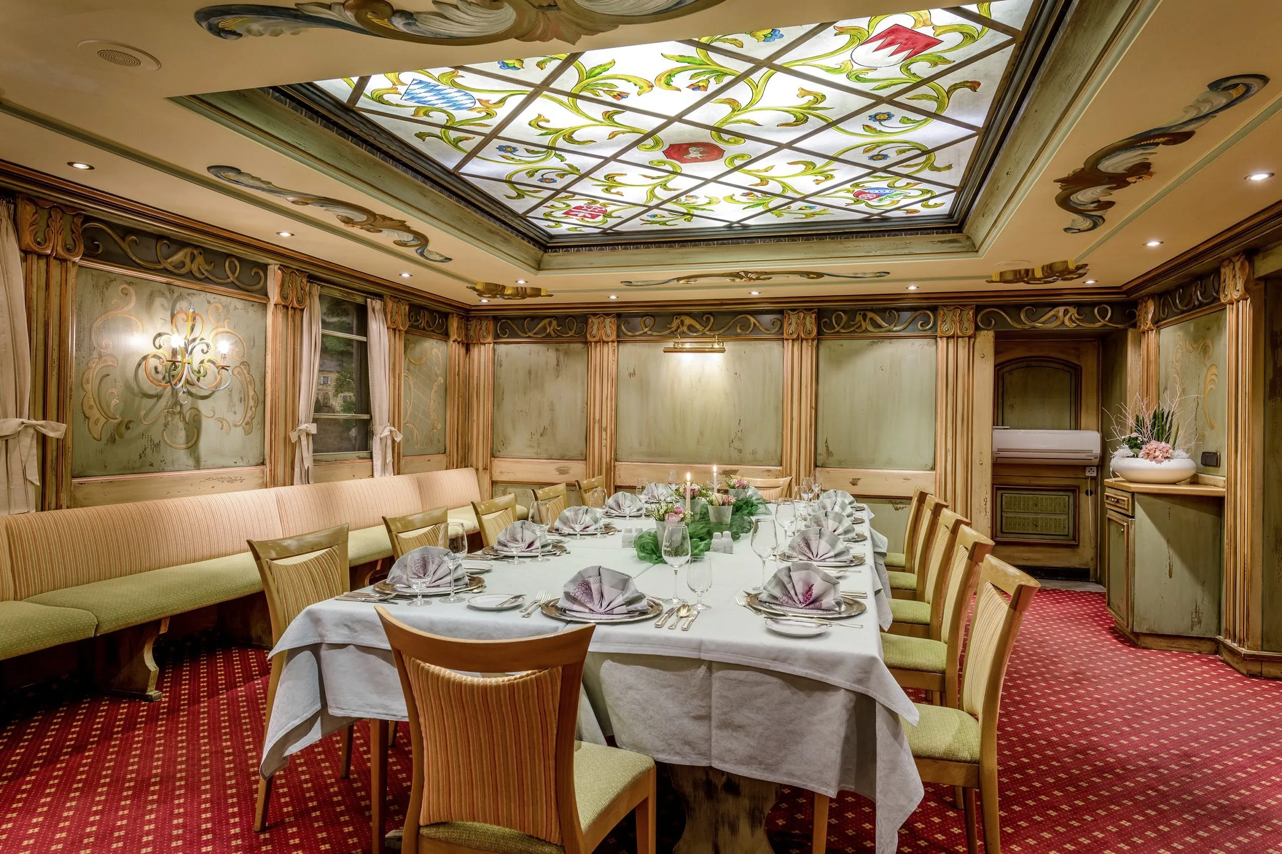 Speiseraum mit eingedecktem Tisch und bemalter Glasdecke des Hotel Lamm