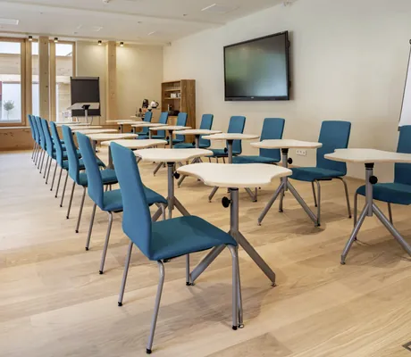 Tagungsraum mit Puzzleartigen Tischen und blauen Stühlen im Posthotel Achenkirch