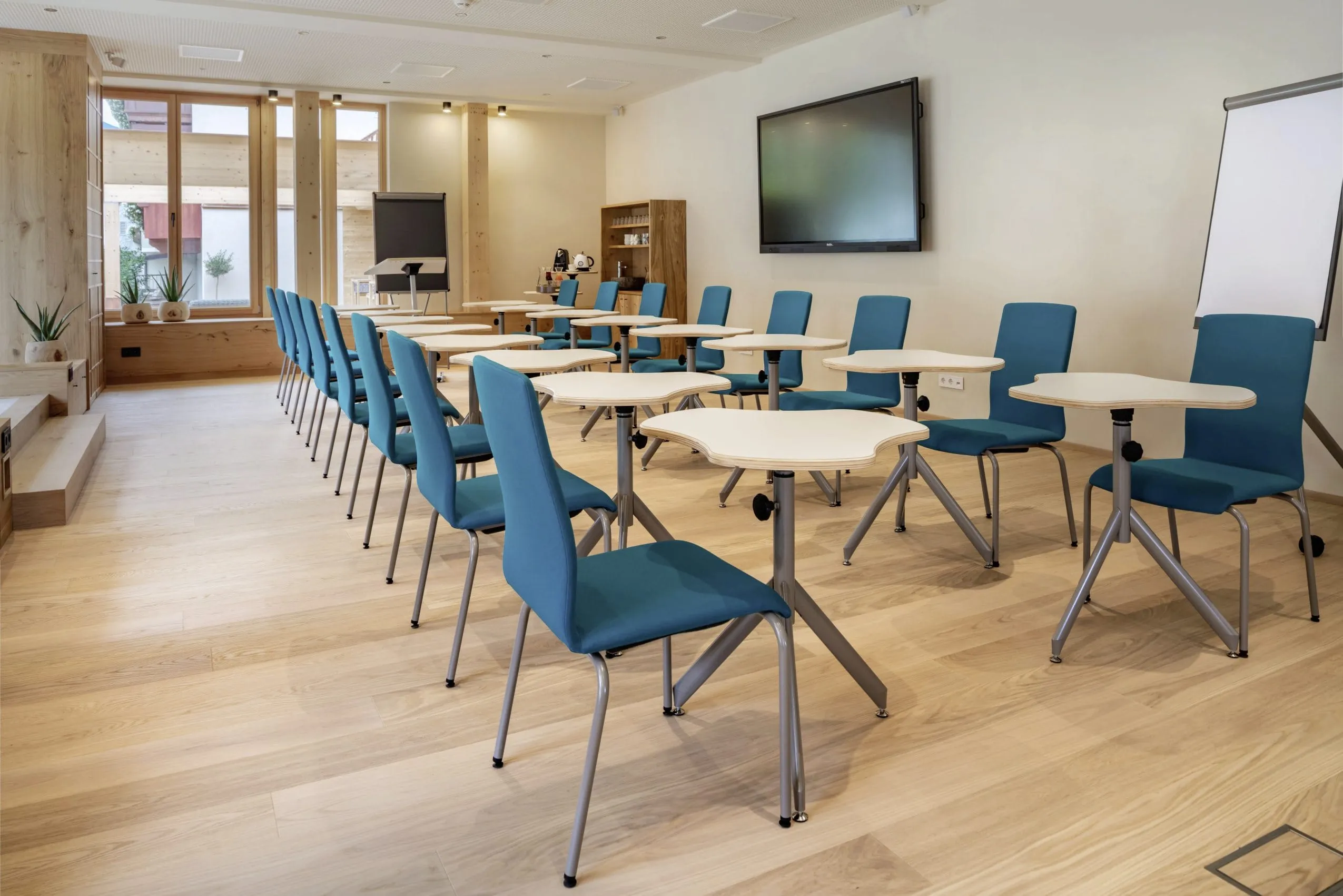 Tagungsraum mit Puzzleartigen Tischen und blauen St&uuml;hlen im Posthotel Achenkirch