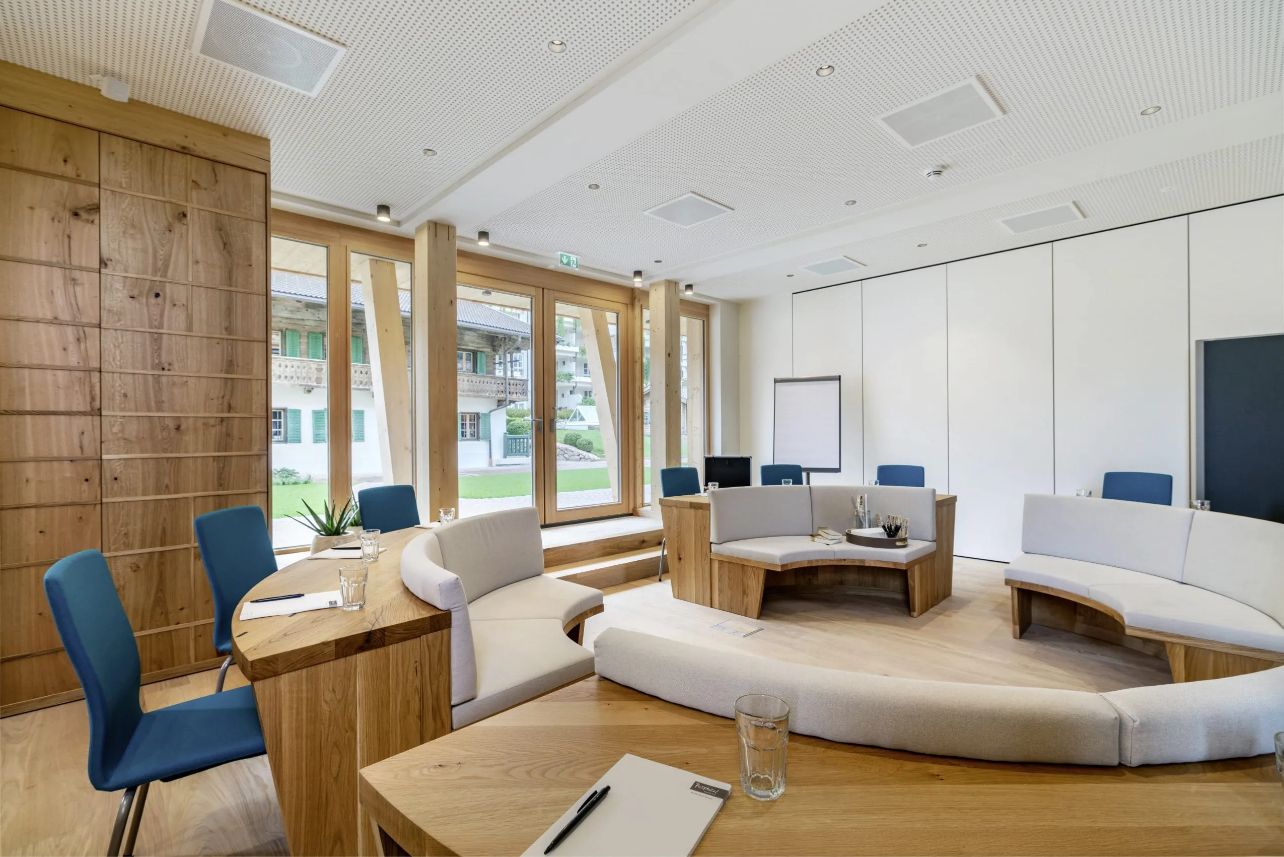 Kreativraum mit runder Sitzecke und blauen St&uuml;hlen im Posthotel Achenkirch