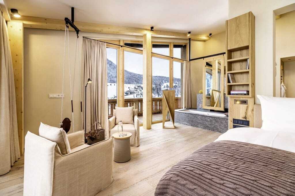 Suite mit integrierter Badewanne und Leinensesseln im Posthotel Achenkirch