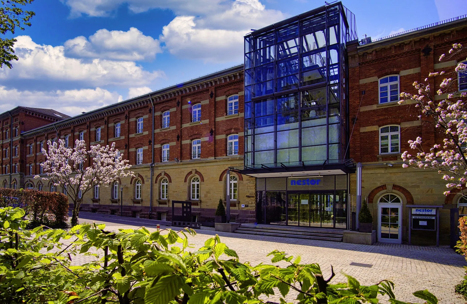 Backsteinfassade mit Stahl-Glas-Einbau und Eingang des Tagungshotes nestor Hotel Ludwigsburg