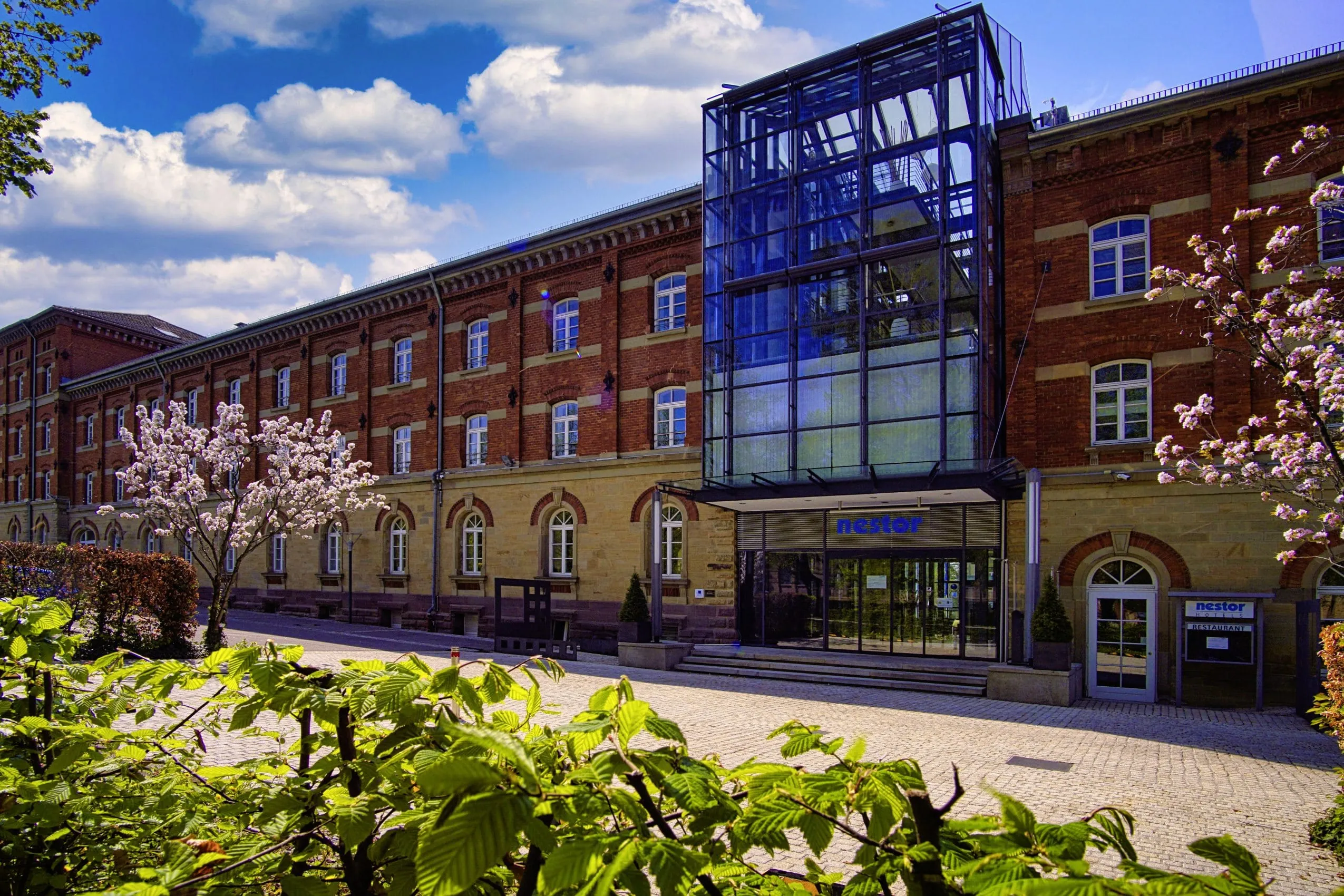 Backsteinfassade mit Stahl-Glas-Einbau und Eingang des Tagungshotes nestor Hotel Ludwigsburg
