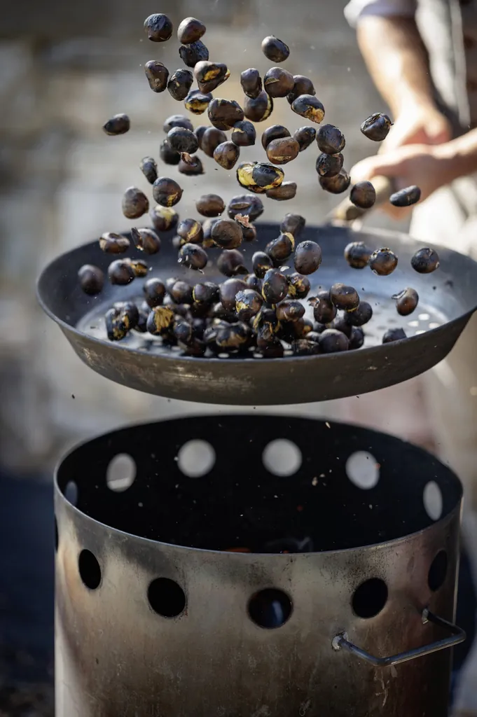 beim Törggelen werden Kastanien über offener Feuerstelle in einer Pfanne geröstet und dabei hochgeworfen