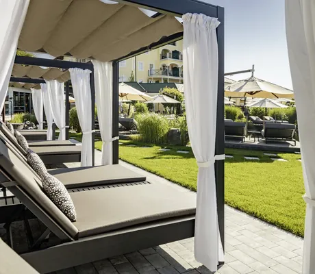 Daybeds mit weißen Vorhängen im Wellnesshotel Jagdhof Röhrnbach