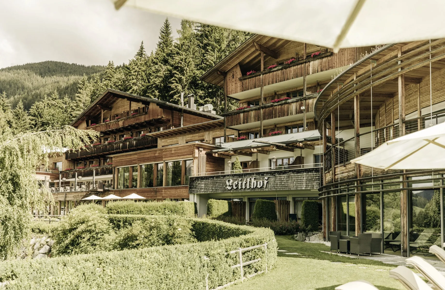 Holzfassade aus Altholz und Schriftzug des Naturhotel Leitlhof über dem Eingang