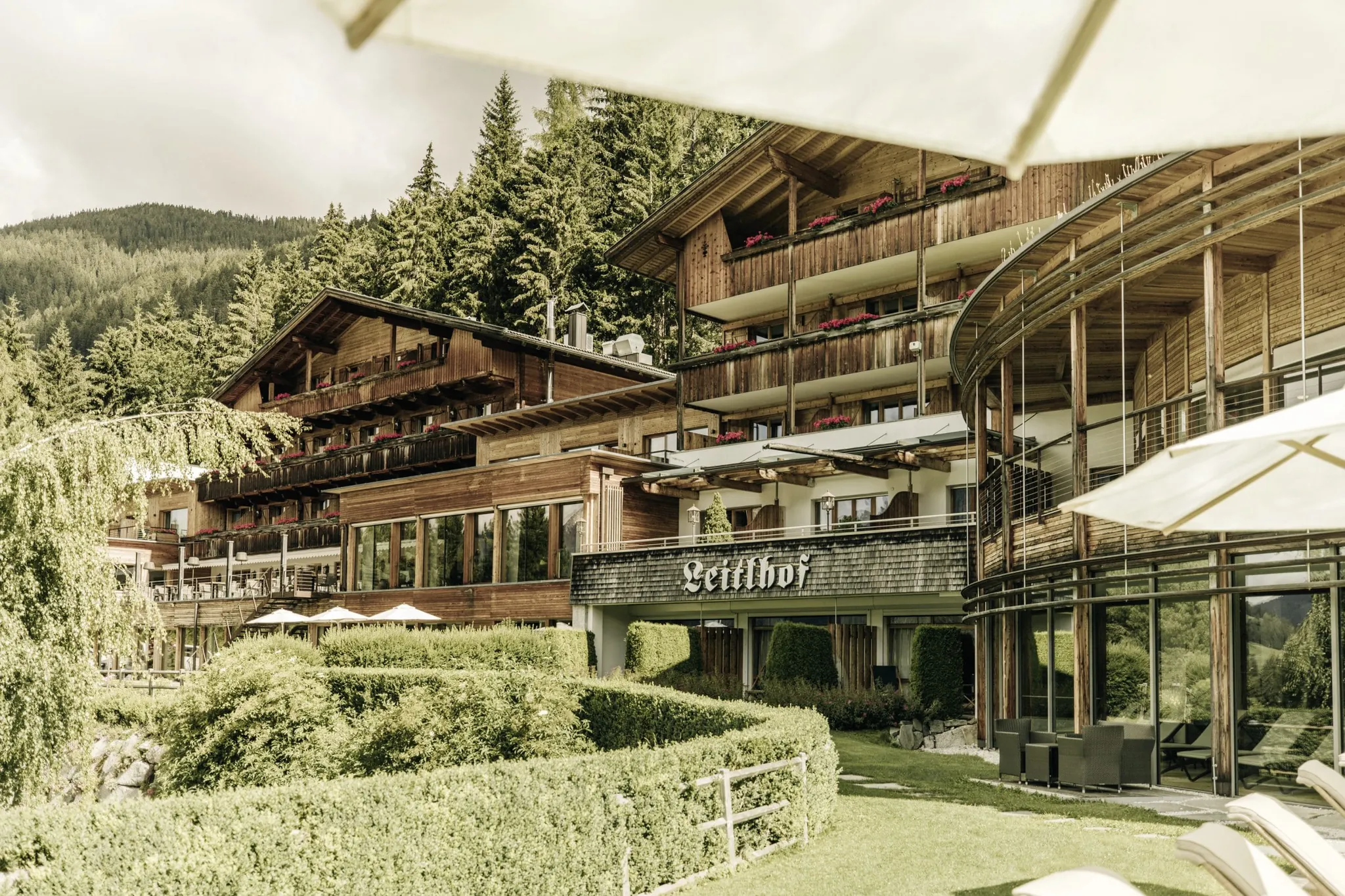 Holzfassade aus Altholz und Schriftzug des Naturhotel Leitlhof über dem Eingang