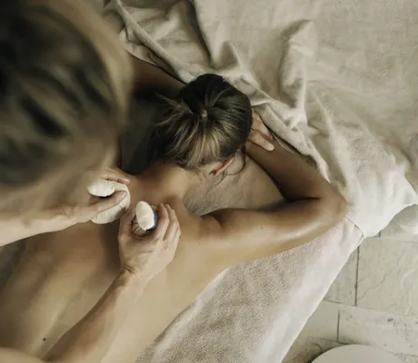 Frau erhält Kräuterstempelmassage im Naturhotel Leitlhof