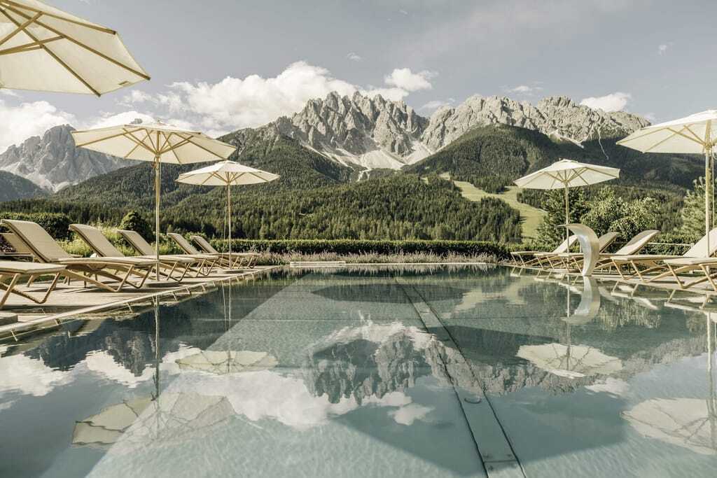 Blick über den Outdoorpool auf die Sextner Dolomiten im Naturhotel Leitlhof