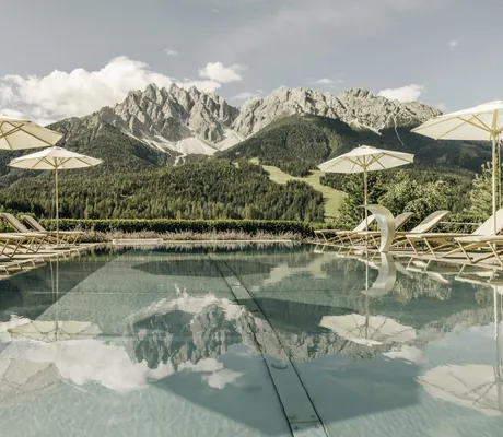 Blick über den Outdoorpool auf die Sextner Dolomiten im Naturhotel Leitlhof
