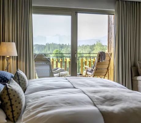 Blick vom Doppelbett über den Balkon auf die Allgäuer Bergwelt im Sonnenalp Resort