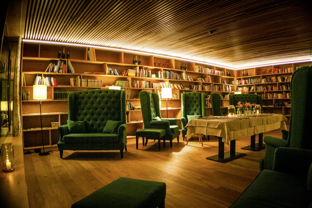 gr&uuml;ne samtene Ohrensessel in der Bibliothek des Mental Spa Resort Fritsch am Berg