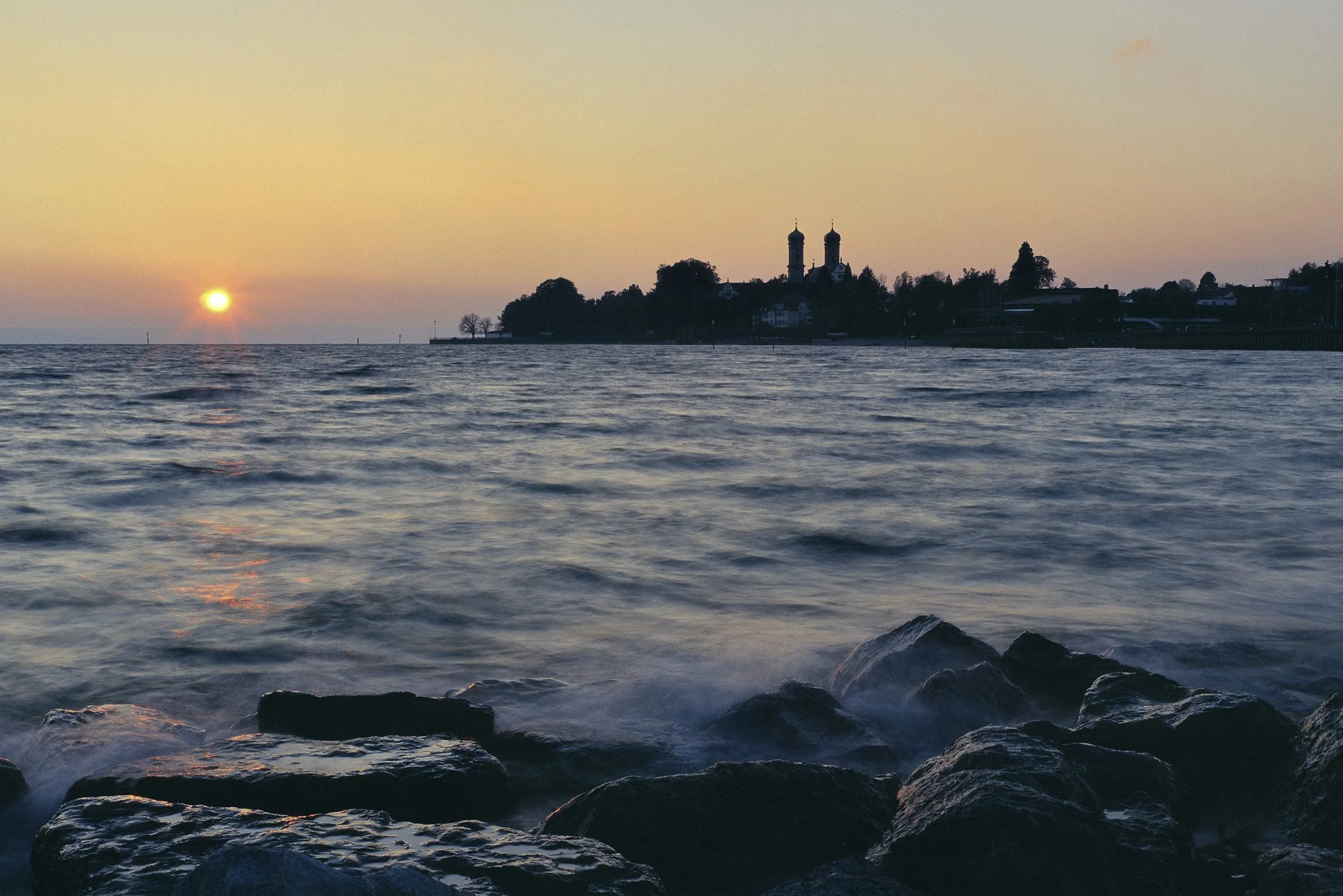 Blick auf Friedrichshafen &uuml;ber den Bodensee in der Abendsonne