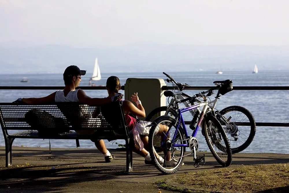 Paar auf Bank am Bodensee mit angelehnten Fahrr&auml;dern in der Krone Schnetzenhausen