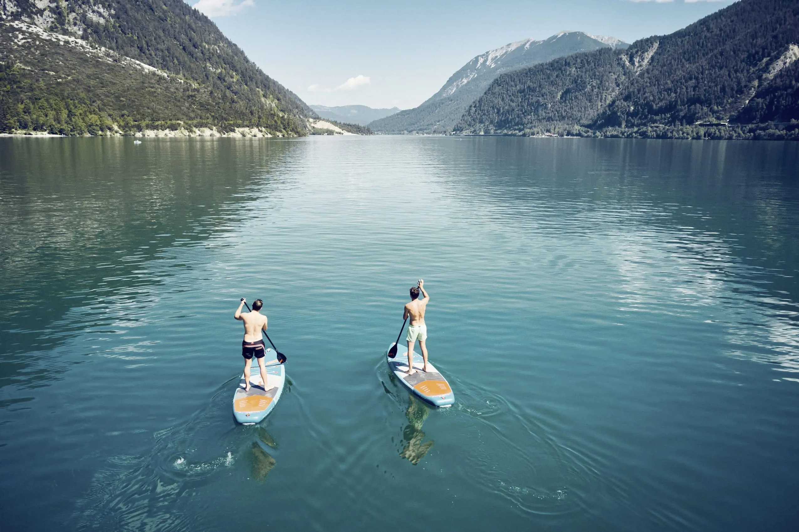 Zwei M&auml;nner paddeln auf ihren Stand Up Paddel-Boards auf dem Achensee