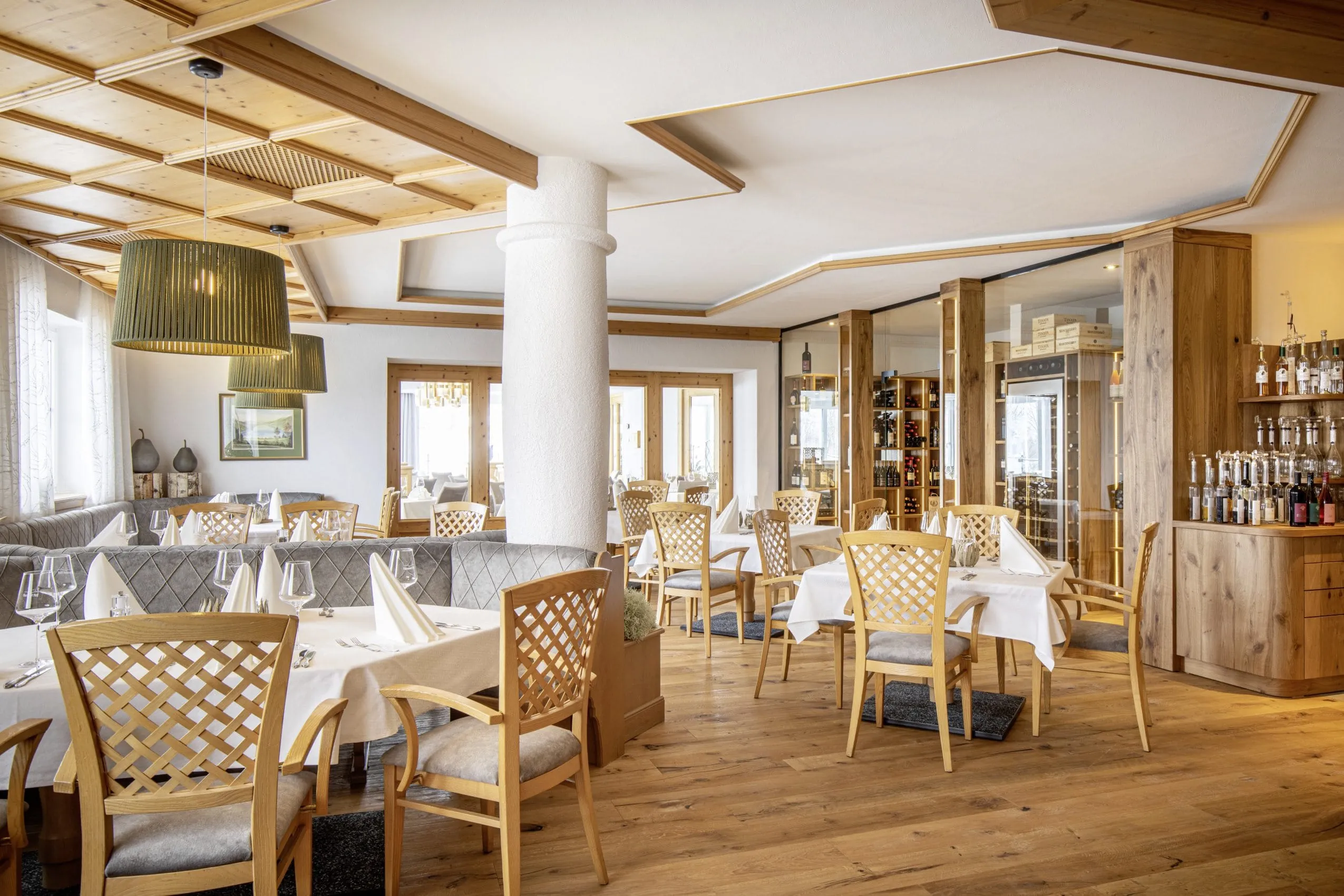 Restaurant des Hanusel Hof mit eingedeckten Tischen und Vinothek im hinteren Bereich