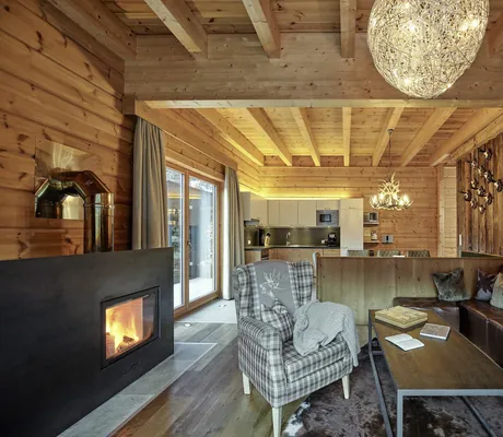 Blick in das im alpin-chich eingerichtete Luxury Apartment Sonnenhang mit Wohnbereich im Vordergrund und Küche im Hintergrund