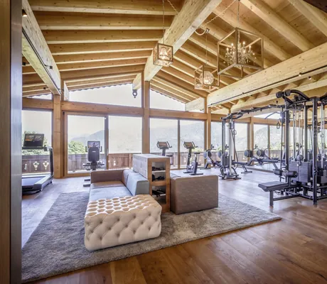 Moderner Fitnessbereich im Peternhof Wohlfühlresort mit TechnoGym-Geräten und großen Panoramafenstern