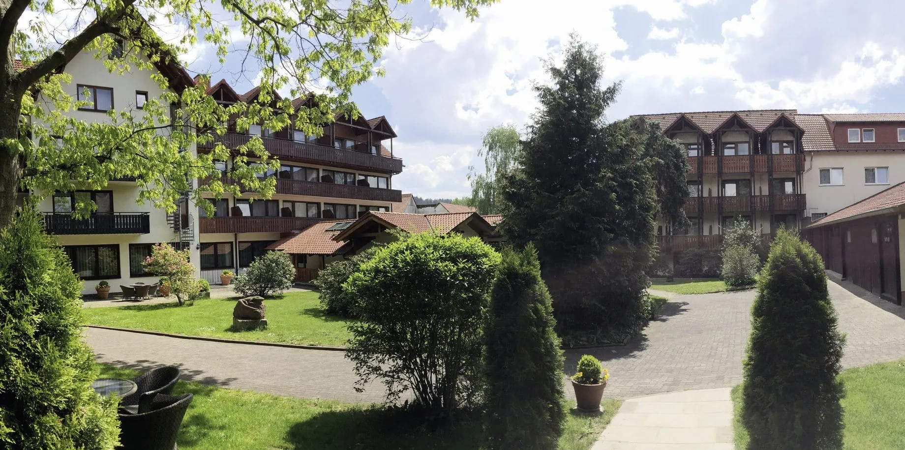 Parkansicht mit mehreren Hoteltrakten mit Holzbalkonen des Parkhotel zum Stern