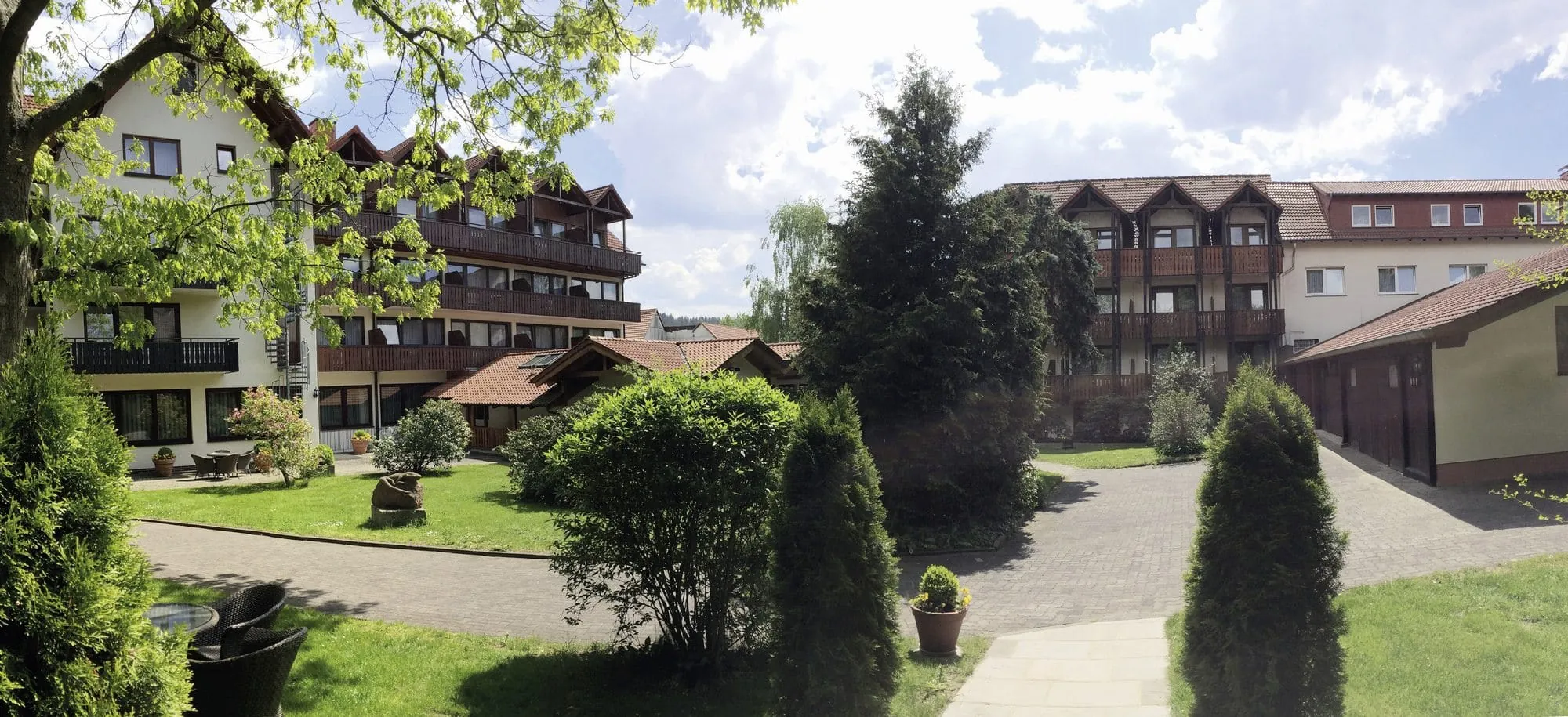 Parkansicht mit mehreren Hoteltrakten mit Holzbalkonen des Parkhotel zum Stern