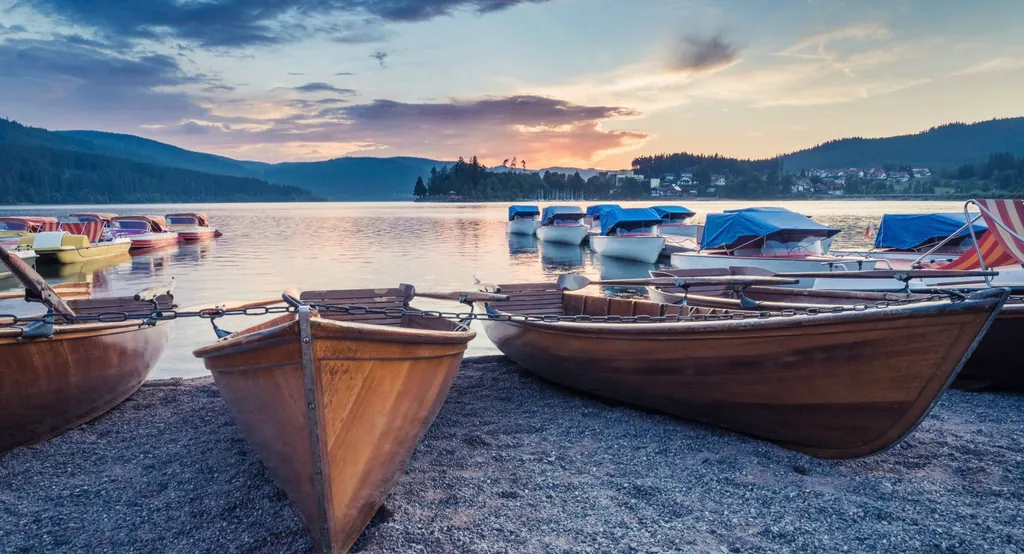 Blick auf den Schluchsee im Schwarzwald bei Sonnenuntergang mit Ausflugsbooten im Vordergrund