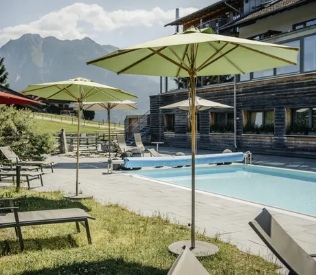 Aussenpool mit Liegen und Marktschirmen