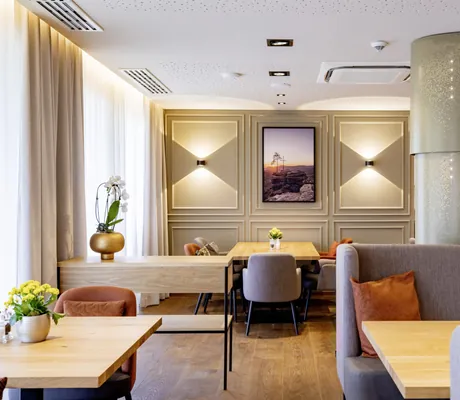 Restaurantstuben mit dicker silberner Säule und Möbeln in Orange und Grau im Pfalzblick Wald Spa Resort