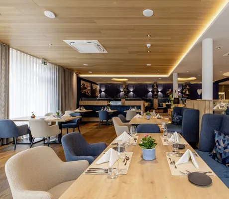 eingedeckte Tische im Restaurant mit blauen und grauen Polstern im Pfalzblick Wald Spa Resort