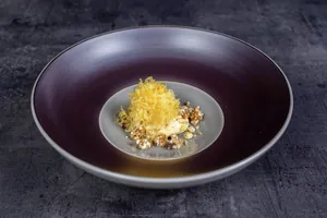 Gericht mit gerösteten Zwiebeln auf dunkellila Teller im Romantischer Winkel