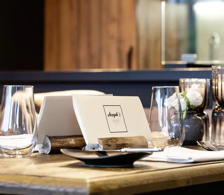 eindeckter Tisch mit Holzstock mit Speisekarte im Josephs steht im Romantischer Winkel