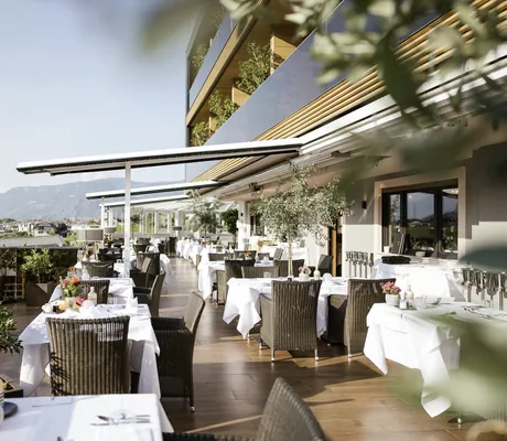 eingedeckte Tische auf der Restaurantterrasse mit Blick auf die Berge rund um das Weinegg Wellviva Resort