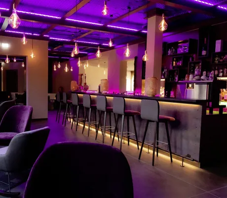 violett beleuchtete Bar mit modernen Hängeleuchten im Bornmühle