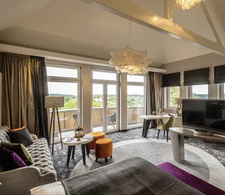 Blick in die stylische Suite des Hotel Heinz mit goldenem Spiegel und Rundumbalkon