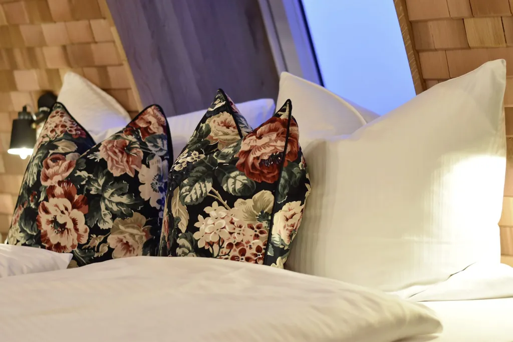 Hübsche Kissen auf dem Bett im Baumhaushotel Allgäu