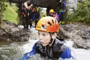 Gruppe beim Canyoning mit kleinem Jungen im Vordergrund