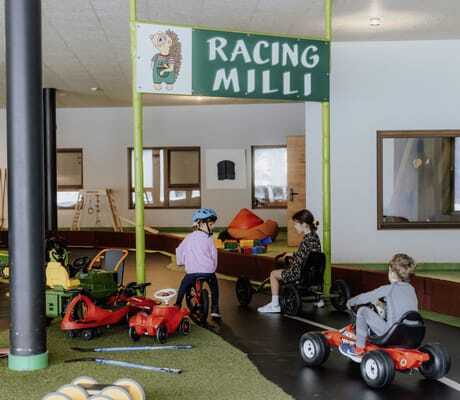 Kinder fahren mit Kinderfahrzeugen auf dem Parcours im Das Mühlwald