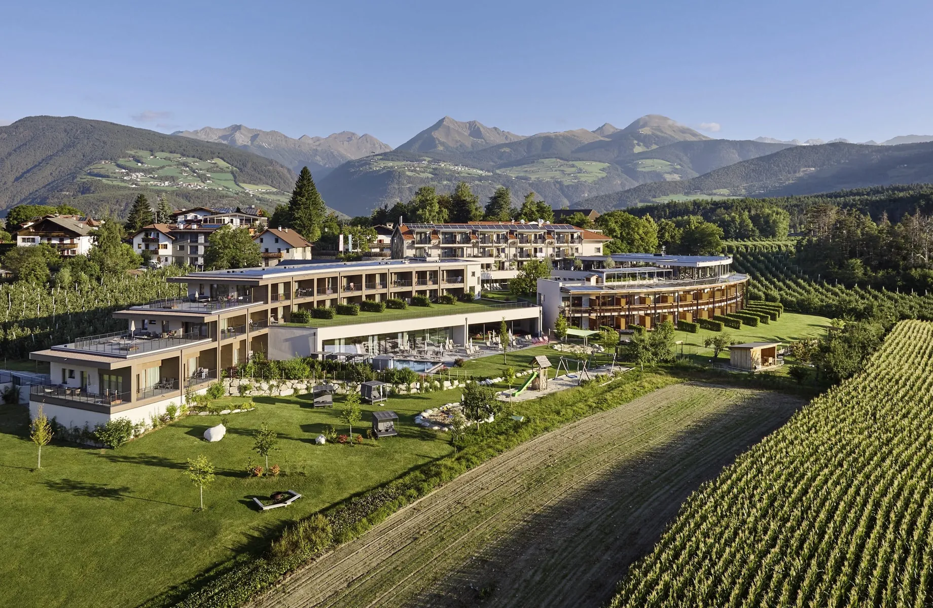 Gesamtansicht des Das Mühlwald im Sommer mit Blick auf die Apfelplantagen
